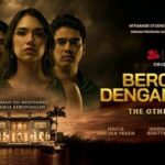 Promotional poster for bercinta dengan maut with four leads standing in front of a mansion by water at sunset title in bold yellow text